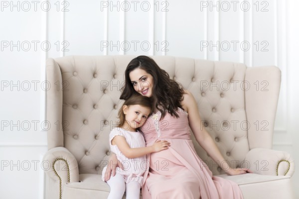 Young happy woman embrace with small daughter. Love and family concept