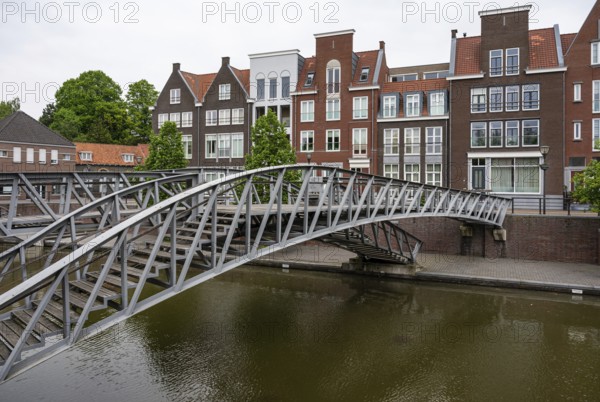 Hulst, Zeeland, The Netherlands, May 21, 2023, Pedestrian bridge and historical buildings at the water of the canal in old town, Europe