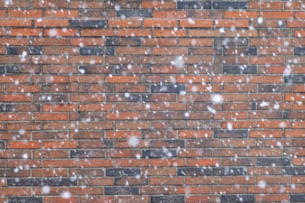 Snowflakes in front of a brick wall