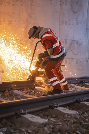 Construction worker grinding rails in a tunnel, sparks flying, rail welding, track construction Hermann Hessebahn, Calw, Black Forest, Germany, Europe