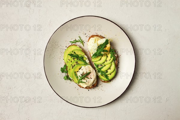 Sandwich with cream cheese, sliced avocado and boiled egg, arugula, on grainy bread, homemade, breakfast, no people