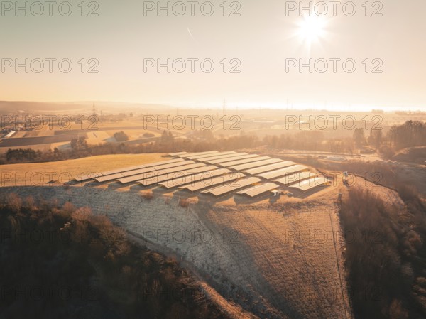 Hilly landscape with solar panels at sunrise, trees and landscape in the background, Magstadt, Germany, Europe