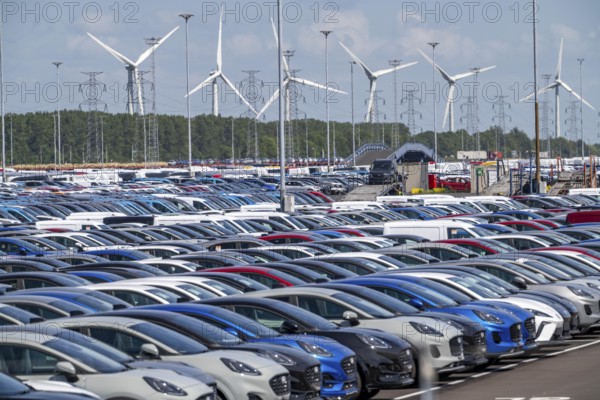 Storage area for new cars in the port of Vlissingen-Oost, vehicles are temporarily stored on over 100 hectares to ship them from Europe to the United Kingdom, Ford cars, others such as models from the Chinese car manufacturer BYD are delivered from here in Europe, wind farm, Netherlands