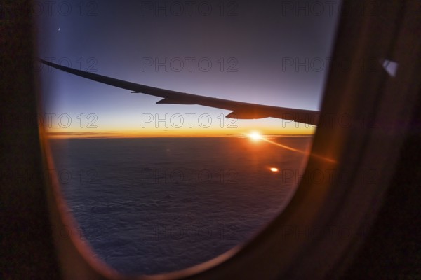 View of the Persian Gulf from the aeroplane window in the evening. Sunset over the clouds. Flight with the airline Etihad. Abu Dhabi, United Arab Emirates, UAE, Asia