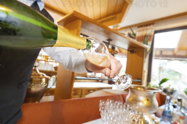 A waiter pours white wine into a glass, wooden decor in the background, Europäischer Hof, Königsbach, Germany, Europe