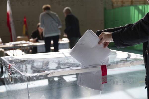 Voter's hand putting the vote into the ballot box.