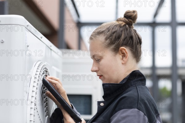 Young technician checks outdoor ventilation system, Freiburg, Baden-Württemberg, Germany, Europe