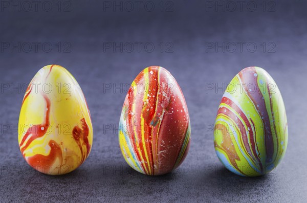 Colorful Easter eggs lined up side by side on a trendy black background