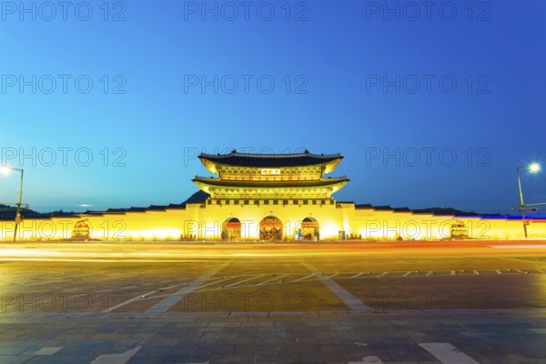 Long exposure car lights leaving a straight light trail in front of Gwanghwamun main entrance gate to Gyeongbokgung Palace in historic part of downtown on a clear, twilight night in Seoul, South Korea, Asia