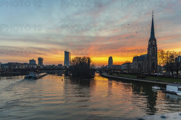 View across the River Main to the ECB and the Protestant Church of the Epiphany. Sunrise in the background of the buildings. Taken in the morning in Frankfurt am Main
