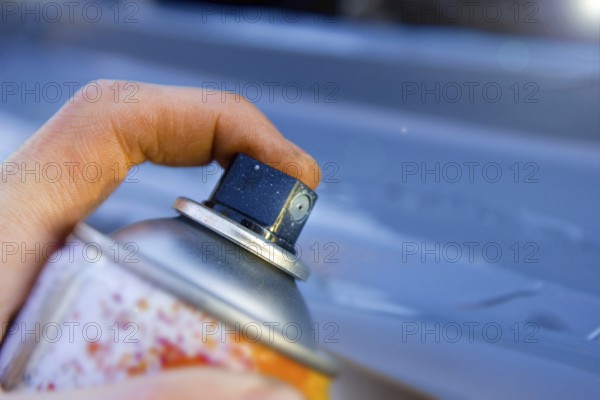 Close view of hand holding spray can, ready for painting