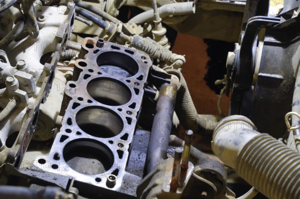 The cylinder block of the four-cylinder engine. Disassembled motor vehicle for repair. Parts in engine oil. Car engine repair in the service