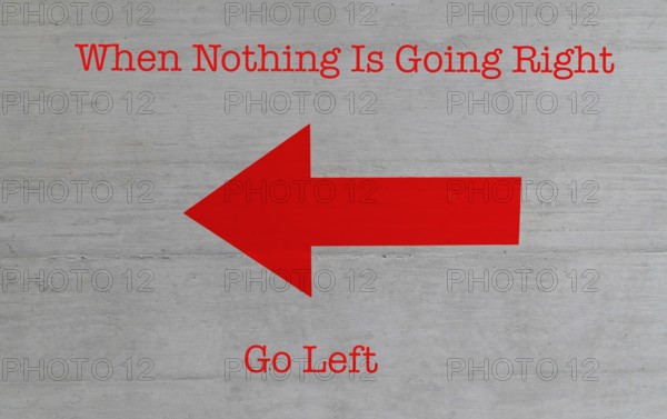 A bright red arrow pointing left on a conrete wall with humorous text