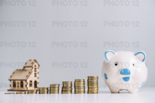 Stack increasing coins piggybank front house model