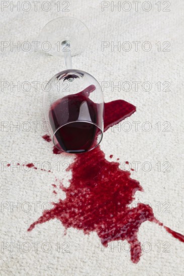 A toppled glass of red wine soils a carpet, A toppled glass of red wine with a dirty carpet. Austria