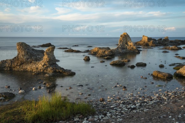 The famous limestone cliffs (Raukar) of Folhammer near Ljugarn on the island of Gotland in the light of an early morning in summer. Long exposure. The famous limestone rocks (raukar) at Folhammar near Ljugar on the swedish island Gotland in teh very early morning light