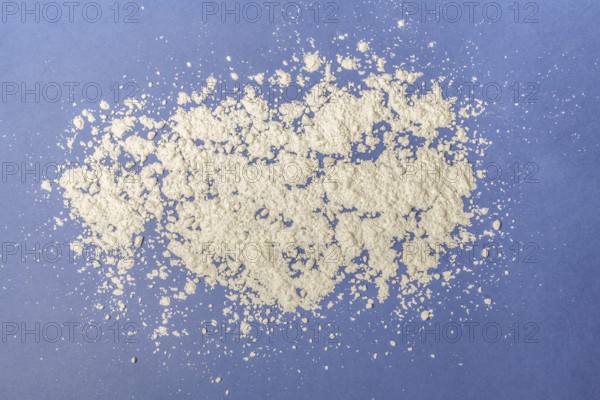 Background photograph of flour sprinkled on a blue background and copy space
