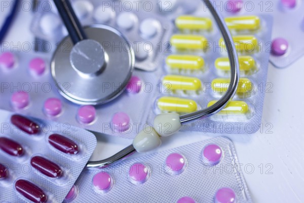 Various medication blister packs and a stethoscope on a table