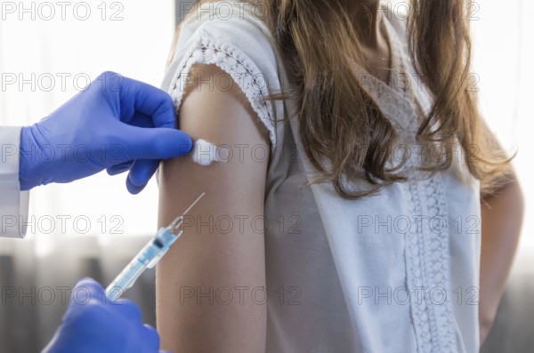 Close up doctor holding syringe and using cotton before make injection to patient in medical mask. Covid-19 or coronavirus vaccine