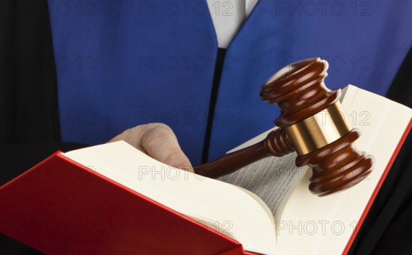 A judge with a law book in court. Gavel in hand, A judge with a law book in court. Gavel in hand. Austria