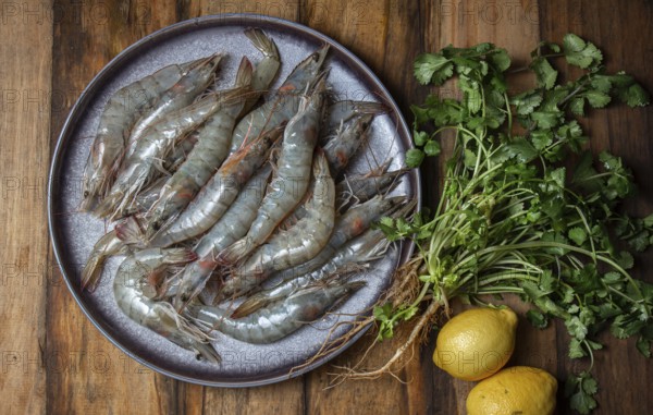 Food, Food, Raw shrimps prawns on gray plate with lemons and cilantro. Top view, wooden background