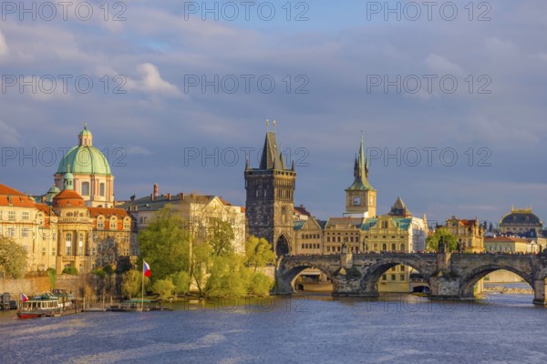 Charles Bridge (Karluv Most) on Vltava river and Old Town Bridge Tower, famous tourist destination in Prague, Czech Republic (Czechia), at sunset