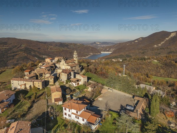 Aerial view of vezzolacca, a charming village nestled in the hills of Val Tolla, Vernasca, piacenza, italy, showcasing the vibrant autumn foliage and surrounding landscape
