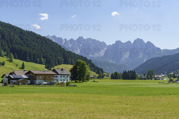 A small village surrounded by green meadows and mountains under a clear blue sky, Gosau, Austria, Europe