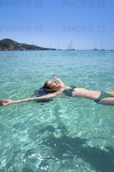 Ibiza bikini girl swimming clear water beach of Balearic Islands