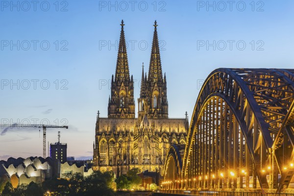 Cologne Cathedral, illuminated in the evening. Hohenzollern Bridge, railway bridge over the Rhine. City view of Cologne, North Rhine-Westphalia, Germany, Europe