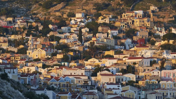 Villas spread over hills, warm light of the rising sun, picturesque and quiet, Symi Town, Symi, Dodecanese, Greek Islands, Greece, Europe