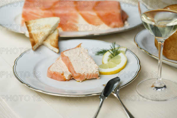 Southern German cuisine, salmon trout terrine arranged on a plate, salmon terrine with trout fillets, fish dish, salmon fillets, smoked salmon, starter, fine dining, Sunday crockery with gold rim, grandma's service, lemons, dill, fish cutlery, toast, food photography, studio, Germany, Europe