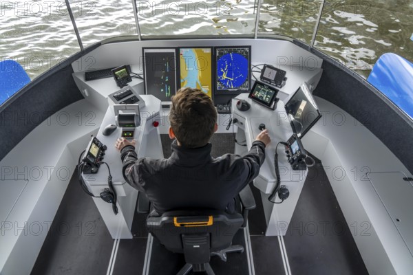 Research vessel Nova, on the Rhine, in the inland port of Ruhrort in Duisburg, 15 metre catamaran, with solar system and electric drive, which serves as a research platform for autonomous driving of ships, testing of alternative, energy-saving, emission-free drives and assistance systems for shipping, steering position, project of the University of Duisburg-Essen, the DST, INAM and JRF, maiden voyage in Duisburg, North Rhine-Westphalia, Germany, Europe
