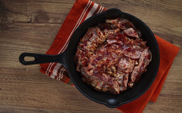 Crispy bacon, on a cast-iron skillet, on a wooden table, rustic style, no people
