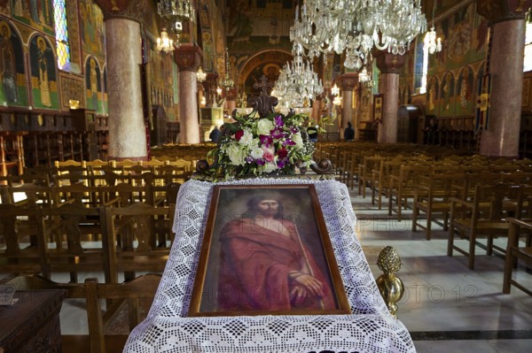 Large church room with a portrait of Jesus and floral decorations on an altar, surrounded by chandeliers and wooden benches, Church of the Annunciation of the Blessed Virgin Mary, Rhodes Town, Greece, Orthodox Church, Dodecanese, Greek Islands, Rhodes Town, Holy Week, Rhodes, Europe