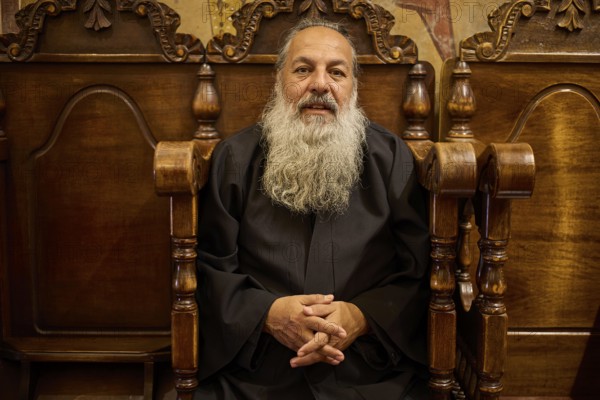 Papas Nektarios, Elderly man with beard on a wooden chair in a quiet, monastic environment, Monastery Thari, Moni Thari, near Gadouras reservoir, lonely mountain region, Rhodes, Dodecanese, Greek Islands, Greece, Europe