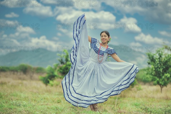 Young Nicaraguan woman in traditional folk costume in a field, smiling at camera