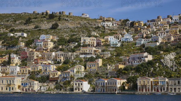 Colourful harbour village on a hill with traditional Greek architecture, Symi Town, Symi, Dodecanese, Greek Islands, Greece, Europe