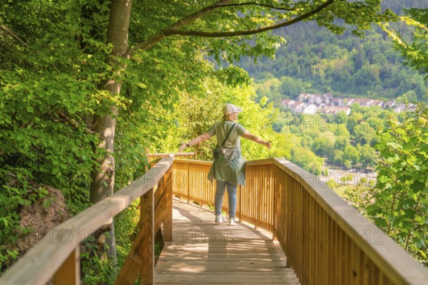 A person walks with outstretched arms on a path and enjoys the view, Panorama Holzsteg, Calw, Black Forest, Germany, Europe