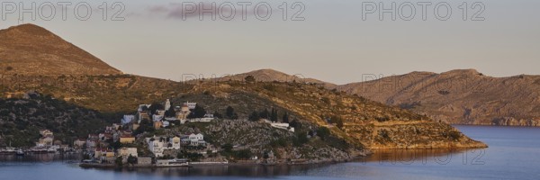 Island in the morning with hills and view of the calm sea in the warm light, Symi Town, Symi, Dodecanese, Greek Islands, Greece, Europe