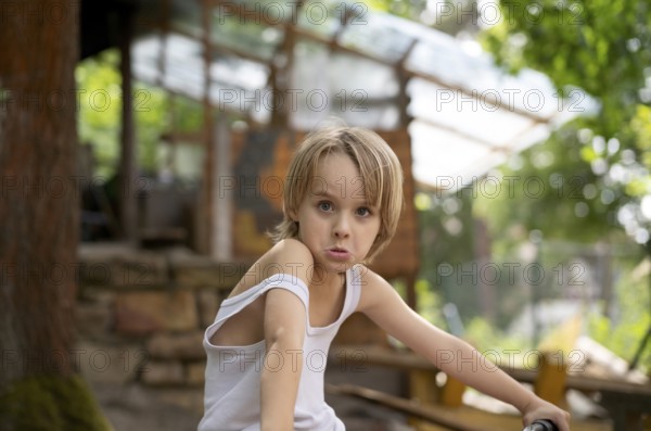 Boy, blonde, 6 years, in vest, gesture, grimace, in the garden, summer, Stuttgart, Baden-Württemberg, Germany, Europe