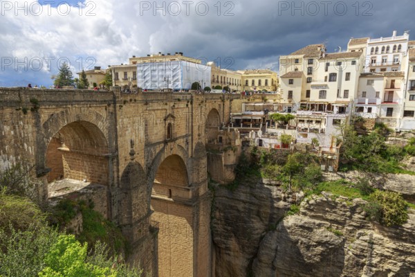 The imposing Puente Nuevo bridge in Ronda, which crosses a deep ravine, surrounded by historic buildings, Ronda, Spain, Europe
