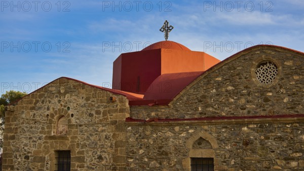 An old church with a red roof and a cross in front of a clear blue sky, Easter 2025, Church of the Dormition of the All-Holy God Bear, Kimisis tis Theotokou, Asklipio, Rhodes, Dodecanese, Greek Islands, Greece, Europe