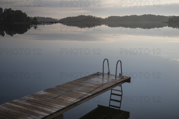 Wooden jetty with ladder, calm water surface, morning atmosphere, Kasnäsintie, Falkö Fjord, Kasnäs, Hitis archipelago, archipelago south of Turku, Finland, Europe