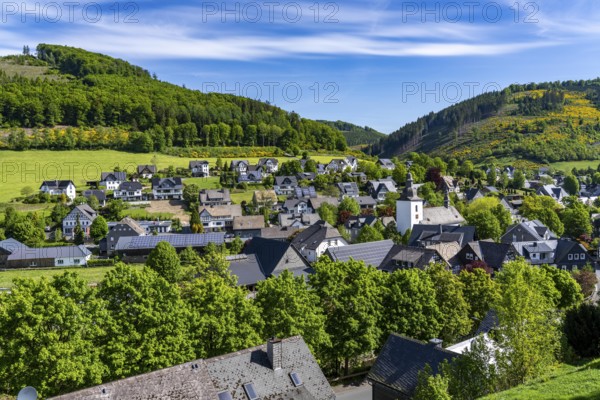 The village of Oberkirchen, district of Schmallenberg, in the Hochsauerland district, St. Gertrudis Church, many residential buildings with photovoltaic modules on the roofs, North Rhine-Westphalia, Germany, Europe