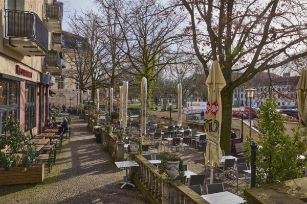 Aresto - Greek restaurant, outdoor area of a catering establishment with tables, chairs and parasols, lantern, bare winter trees, balcony, sidelight, pale blue cloudless sky, monastery corridor, Hanover, state capital, Hanover region, Lower Saxony, Germany, Europe
