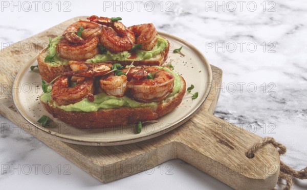 Sandwiches with avocado and caramelized shrimp, micro-greens, breakfast, on a plate, top view, homemade, no people