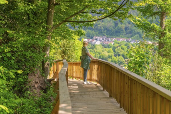 Woman enjoying the view of the village while walking along the wooden path, Panorama Holzsteg, Calw, Black Forest, Germany, Europe