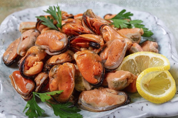 Mussels no shell, boiled, mussels, peeled, in a bowl, with lemon and parsley, Chilean mussels, top view, no people