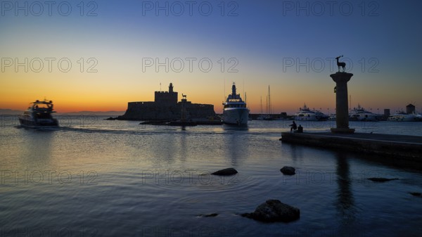 Harbour view at sunset with boats and a fortress, calm sea and evening atmosphere, sunrise, dawn, Fort of Saint Nikolaos, Mandraki Harbour, Rhodes Town, Rhodes, Dodecanese, Greek Islands, Greece, Europe